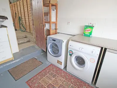 a washing machine and a washer in a kitchen at Y Beudy The Old Byre in Llanbedr