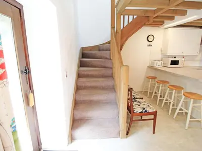 a staircase leading up to the kitchen in a house at Y Beudy The Old Byre in Llanbedr