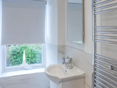 a white bathroom with a sink and a window at Tynffordd Fawr in Penrhyndeudreath