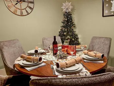 a christmas table with a christmas tree in the background at Tynffordd Fawr in Penrhyndeudreath
