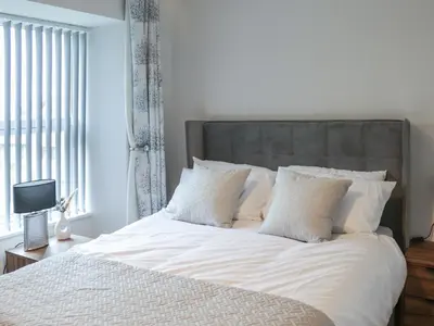 a bed with white sheets and pillows in a bedroom at Tynffordd Fawr in Penrhyndeudreath
