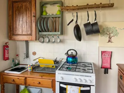 a kitchen with a stove with a tea kettle on it at The Cabin In The Woods - Uk49023 in Pencarreg