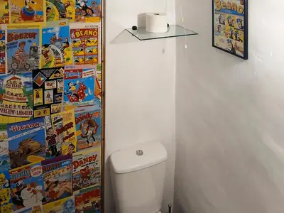 a bathroom with a toilet with comics on the wall at Y Smithy - Uk49022 in Llanybydder