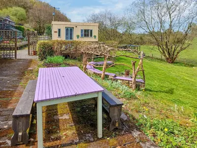 a purple bench sitting in a yard with a house at Rosie - Uk49025 in Pencarreg