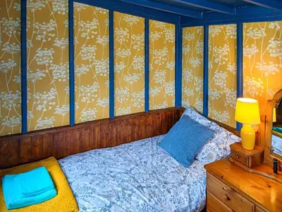 a bedroom with a bed and a lamp and a dresser at Rosie - Uk49025 in Pencarreg