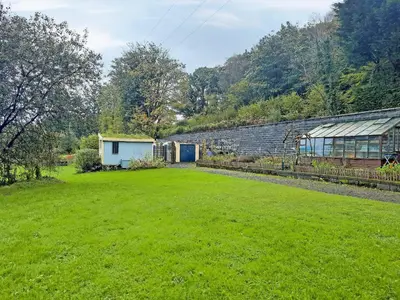 a large yard with a greenhouse and a building at Rosie - Uk49025 in Pencarreg