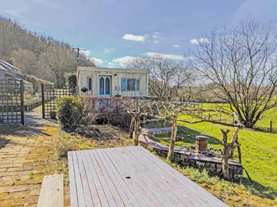 a small house in a field with a wooden deck at Rosie - Uk49025 in Pencarreg