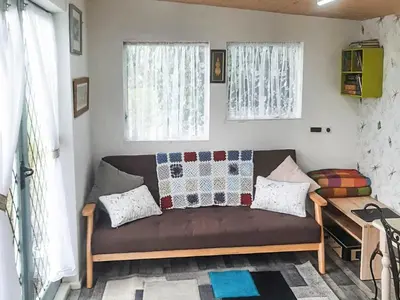 a couch in a living room with two windows at Rosie - Uk49025 in Pencarreg
