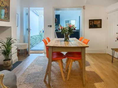 a dining room with a wooden table and orange chairs at Cosy Cwtch in Hay-on-Wye