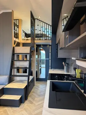 a kitchen with a spiral staircase in a house at Lodges at Moody Meadows in Llanarth