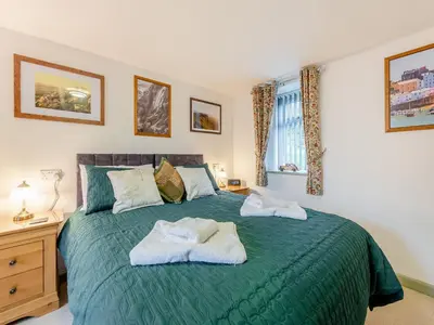 a bedroom with a green bed with towels on it at Rhydyfran Coach House in Cribyn