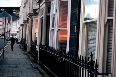 a person walking down a street next to buildings at Awel Mor Holiday Apartment in Aberystwyth