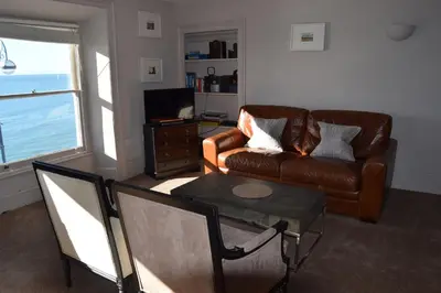 a living room with a couch and a table at Awel Mor Holiday Apartment in Aberystwyth