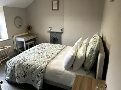 a bedroom with a bed with a fireplace and a table at Beautiful Remote Cottage near Dolgellau in Penmaen Pool