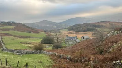 a house on a hill with a stone wall at Beautiful Remote Cottage near Dolgellau in Penmaen Pool