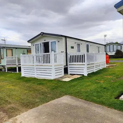 a white house with a white fence in a yard at Willerby Malton in Barmouth