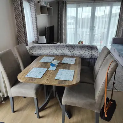 a dining room table with chairs and a couch at Willerby Malton in Barmouth