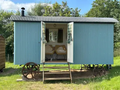 a blue train house with a couch in it at Tower Farm Holidays in Llangollen
