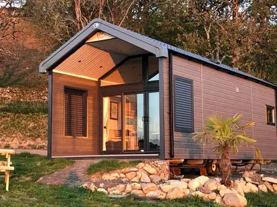 a tiny house with a large window in a yard at POD1 Family Glamping with seaview & Wi-Fi in Llwyngwril