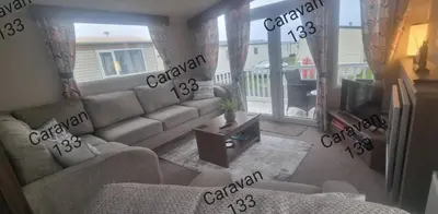 a living room with a couch and a tv at Caravan 133 snowdon summit 090 in Barmouth