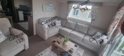 a living room with two couches and a table at Caravan 133 snowdon summit 090 in Barmouth