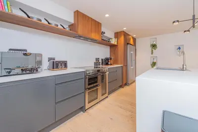 a kitchen with stainless steel appliances and wooden cabinets at Tackroom Great Ness Shrewsbury in Great Ness