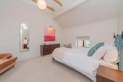 a bedroom with a large white bed and a table at Tackroom Great Ness Shrewsbury in Great Ness