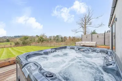 a hot tub on the deck of a house at Tackroom Great Ness Shrewsbury in Great Ness