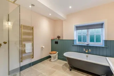 a bathroom with a tub and a toilet and a window at 5 Bed in Church Stretton oc-t30413 in Church Stretton
