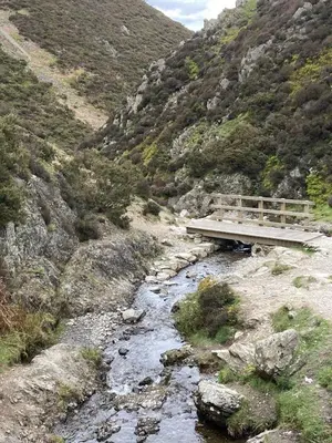 a wooden bridge over a river in a mountain at Broughshane in Church Stretton