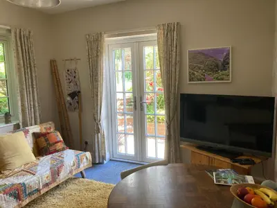 a living room with a flat screen tv and a table at Broughshane in Church Stretton