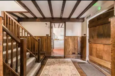 a hallway with a staircase and wooden walls at Bramble Cottage in Atcham