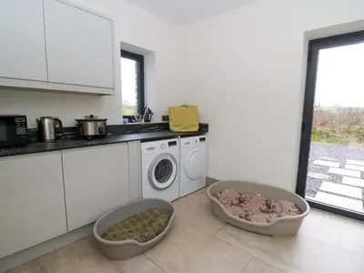 a kitchen with a washing machine and a dishwasher at Rhandir Hen in Aberystwyth