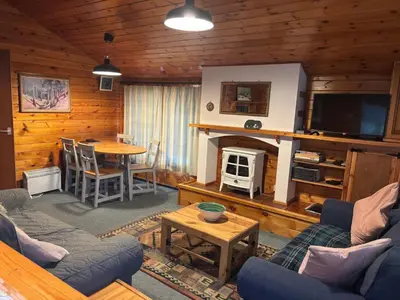 a living room with a couch and a tv and a table at 345 Ida's Cabin in Trawsfynydd