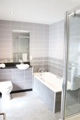 a bathroom with a tub and a toilet and a sink at Gwesty Seren Hotel in Blaenau-Ffestiniog