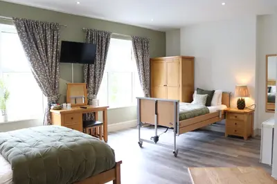 a bedroom with a bed and a desk and window at Gwesty Seren Hotel in Blaenau-Ffestiniog