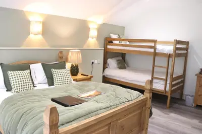 a bedroom with two bunk beds and a desk at Gwesty Seren Hotel in Blaenau-Ffestiniog