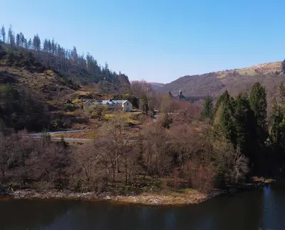 a view of a river with a house on a hill at Ty Penbont House in Rhayader
