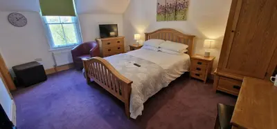 a bedroom with a large bed with a wooden frame at Ty Penbont House in Rhayader