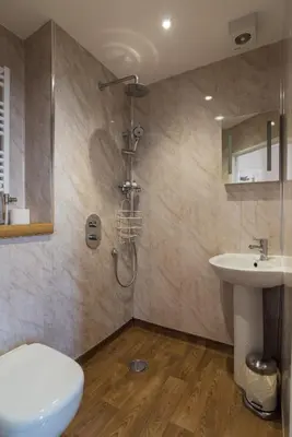 a bathroom with a shower and a toilet and a sink at No 46 Marine Terrace in Aberystwyth