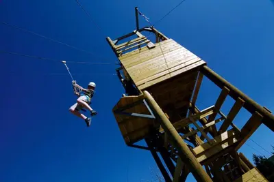 a man is hanging from a tree house at Tan-y-Graig at Snowdonia in Harlech