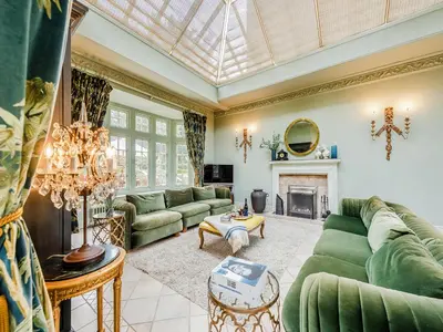 a living room with green couches and a fireplace at Gwynfryn in Llanarth