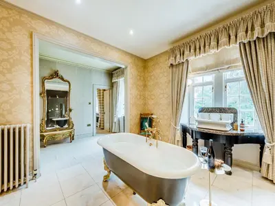 a bathroom with a tub and a sink and a mirror at Gwynfryn in Llanarth