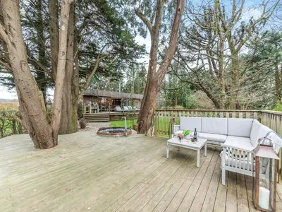 a patio with a couch and a table and trees at Gwynfryn in Llanarth