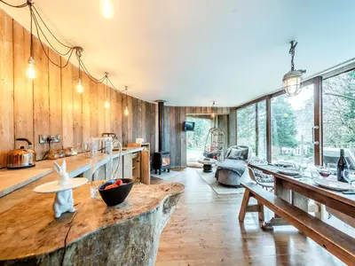 a large kitchen with wooden walls and a large table at Gwynfryn in Llanarth