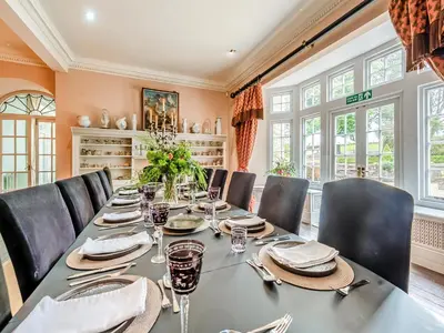 a dining room with a long table and chairs at Gwynfryn in Llanarth