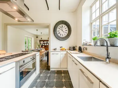 a kitchen with a large clock on the wall at Gwynfryn in Llanarth