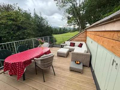 a wooden deck with a table and chairs and a table and chairs at Clywedog Cottage in Dolgellau