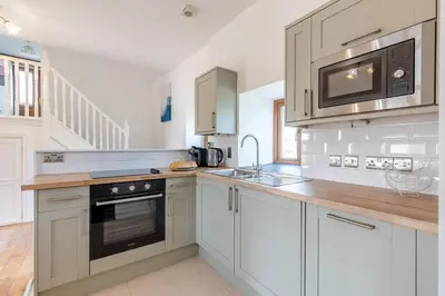 a kitchen with white cabinets and a sink and a microwave at 2 Bed in Rhoslefain oc-i30763 in Llangelynin