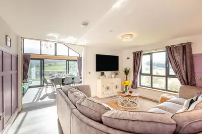 a living room with a couch and a tv at 4 Bed in Berriew oc-t31114 in Berriew